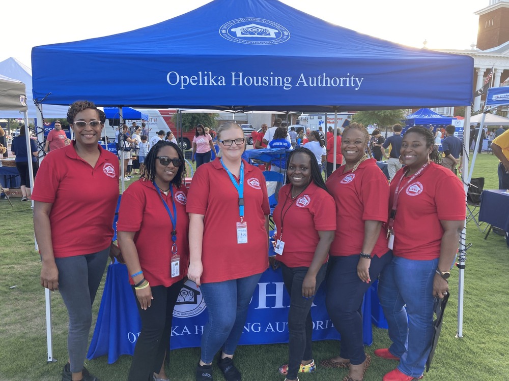 Opelika Housing Authority staff at the National night out in front of the opelika housing authority tent