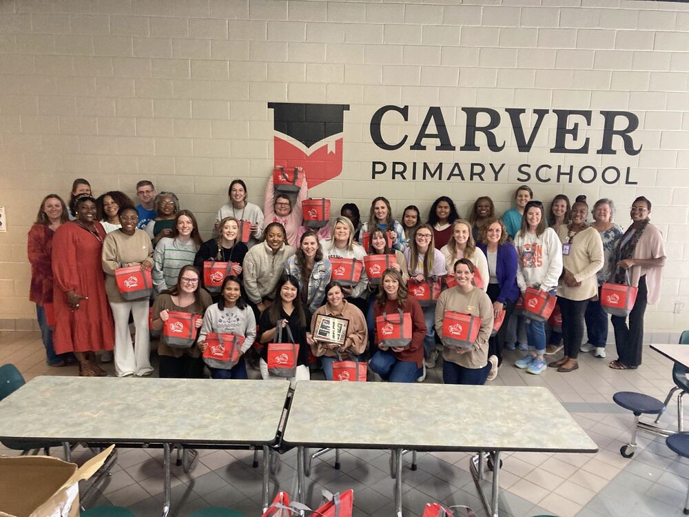 OHA Staff and Carver Primary School teachers posed with red totes